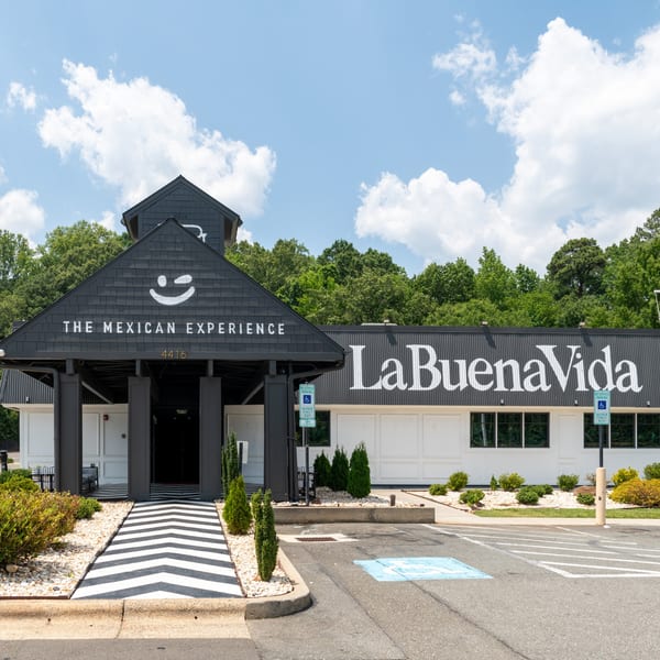 Exterior of La Buena Vida, a Mexican restaurant, with a black and white striped entrance path.