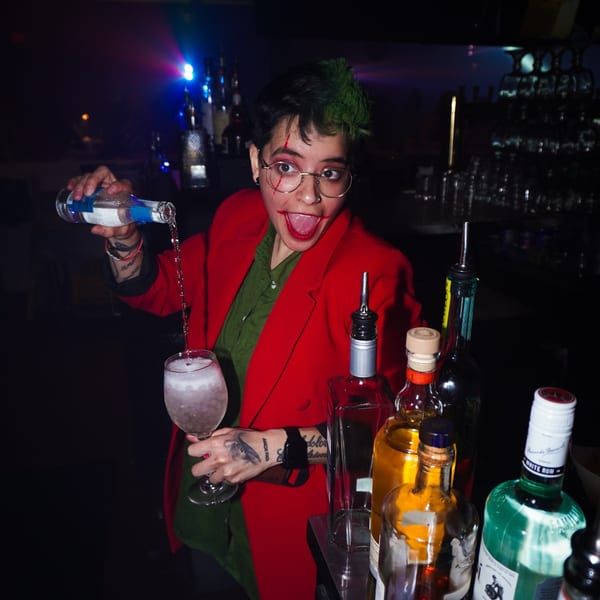 A bartender with Joker-inspired makeup pours a drink at La Buena Vida.