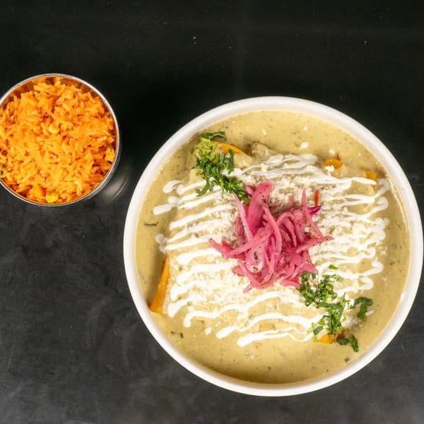Enchiladas with green sauce, cheese, pickled onions, and cilantro, served with a side of orange rice.